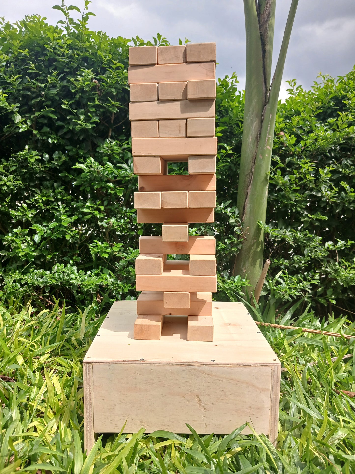 Giant Jenga game in progress with players balancing blocks