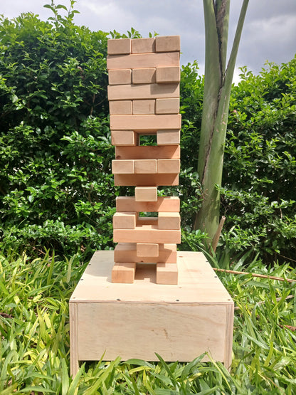 Giant Jenga game in progress with players balancing blocks