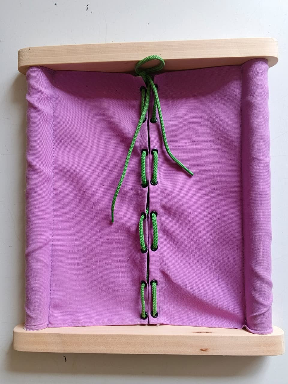 Toddler practicing lacing and threading on Montessori dressing frame