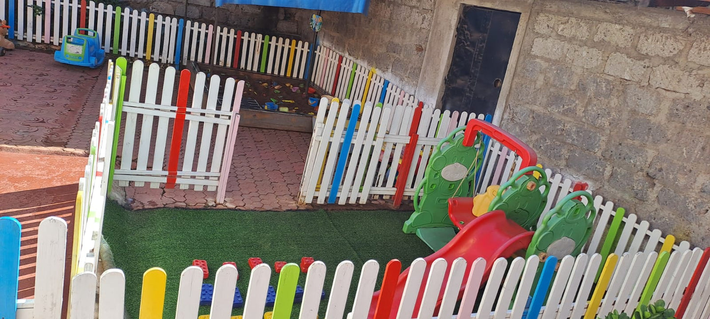 Vibrant wooden picket fence adding charm to backyard play space