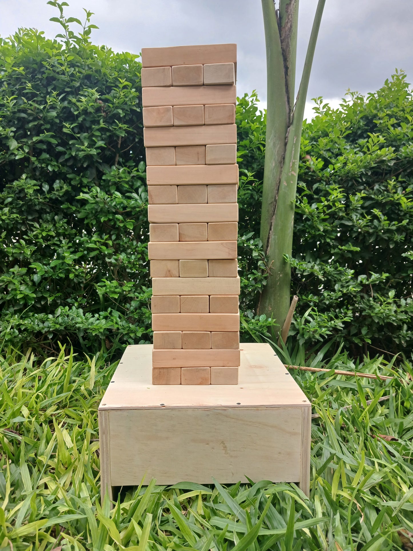 Kids playing with a large wooden Giant Jenga set outdoors