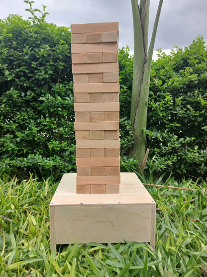 Kids playing with a large wooden Giant Jenga set outdoors