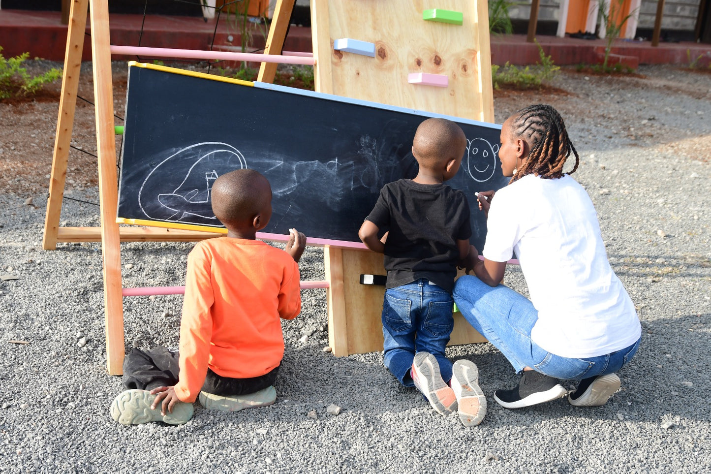 Wooden jungle gym slide that doubles as a chalkboard for creative play